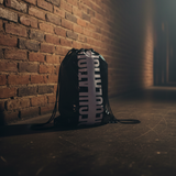 Black drawstring bag with 'REGULATION' text against a brick wall.